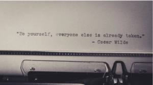 Typewritten Oscar Wilde quote about individuality, used in a blog post about AI grammar, em dashes, and editorial voice.