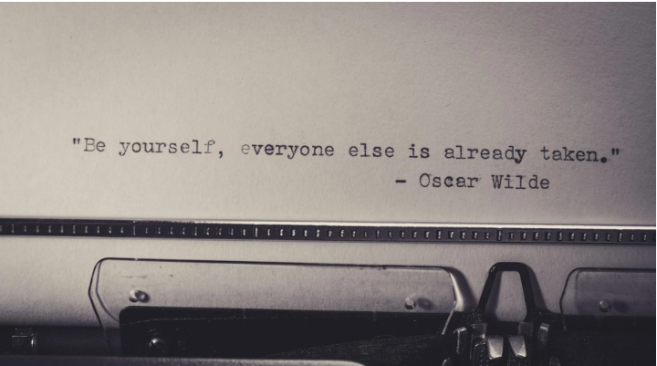 Typewritten Oscar Wilde quote about individuality, used in a blog post about AI grammar, em dashes, and editorial voice.