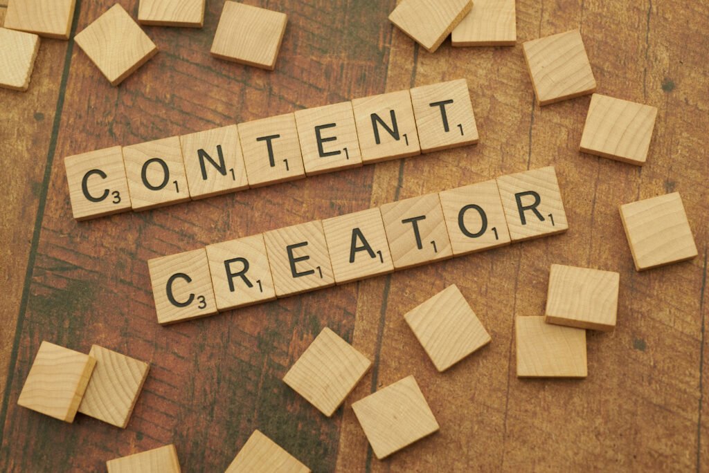 Scrabble tiles spelling out “Content Creator” on a wooden surface.